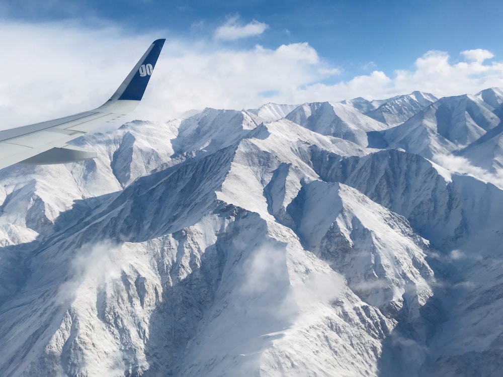 Airplane flying near snow covered mountain during daytime photo