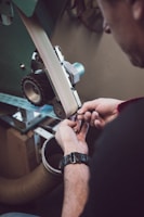 A close-up of a technician carefully sanding a car door in the workshop.