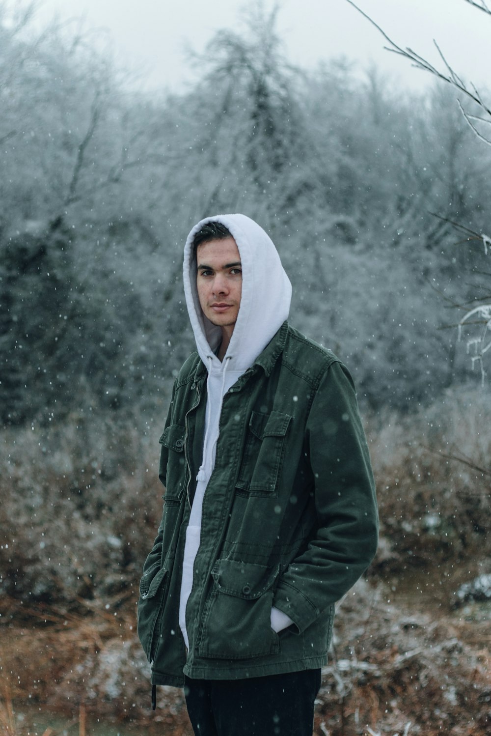 man in grey and green hoodie standing