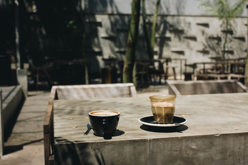 filled ceramic mug and cup on gray wooden table