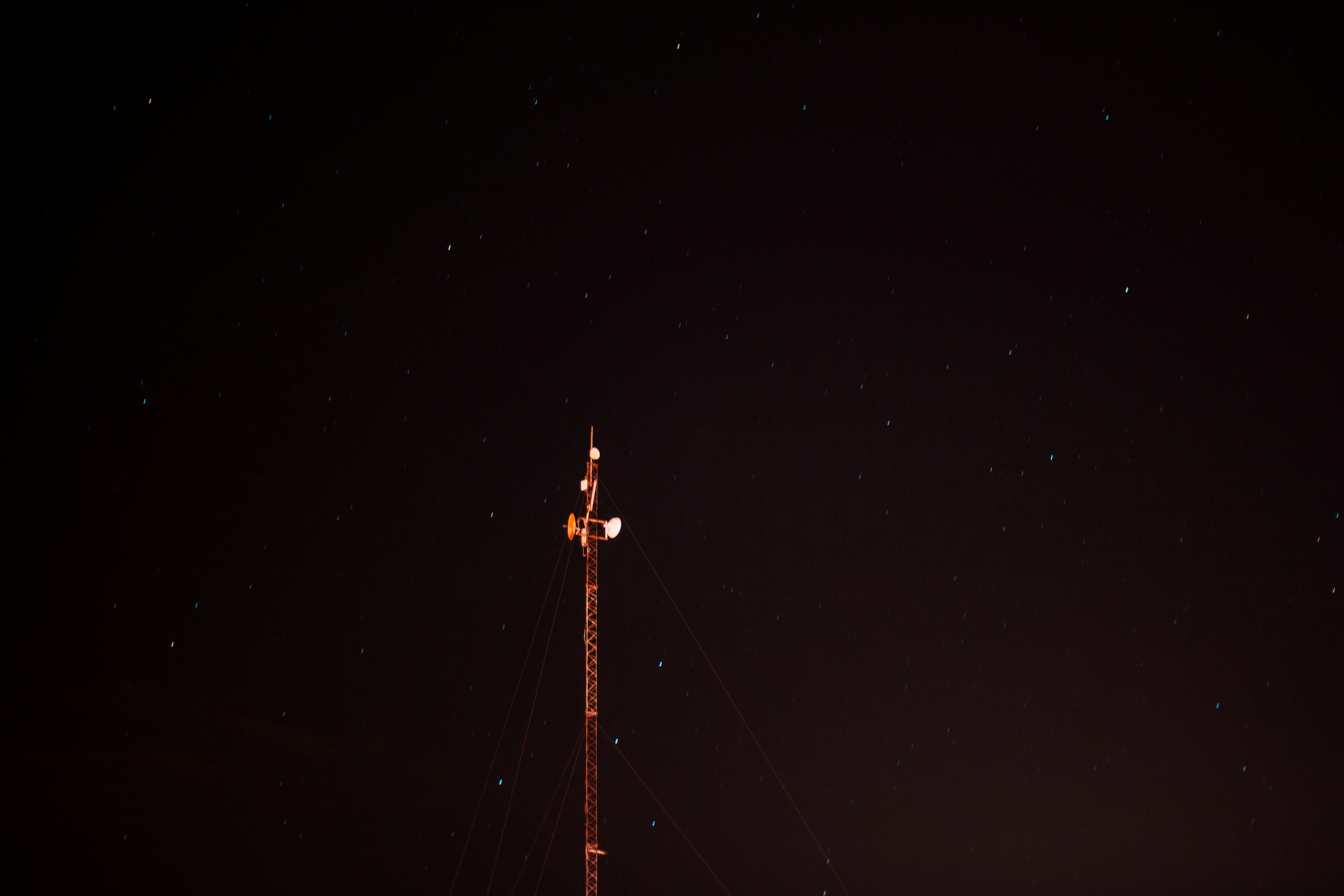 a radio tower at night with stars in the sky