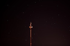 a radio tower at night with stars in the sky