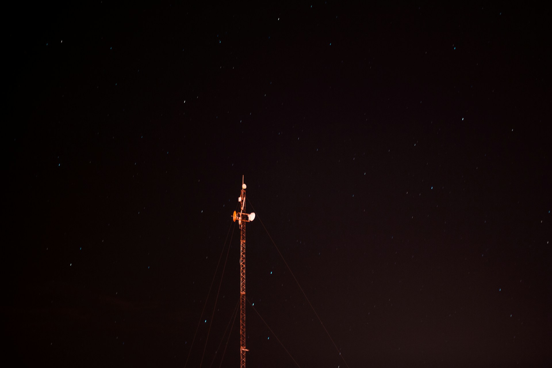a radio tower at night with stars in the sky
