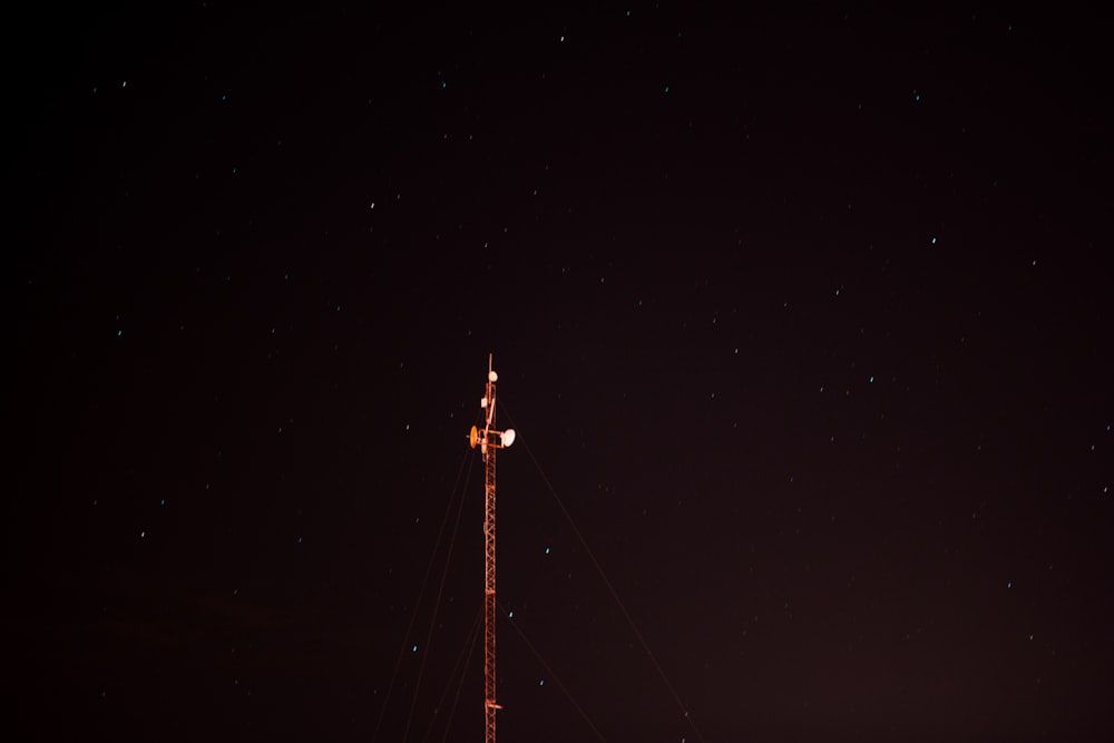 uma torre de rádio à noite com estrelas no céu