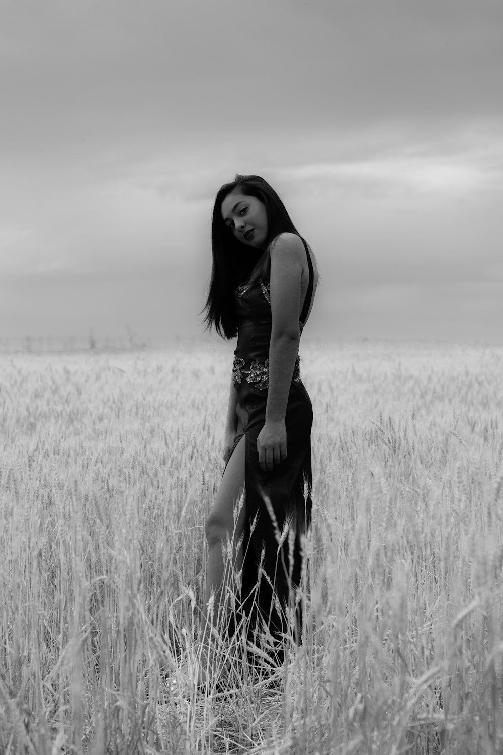 grayscale photo of woman standing on field