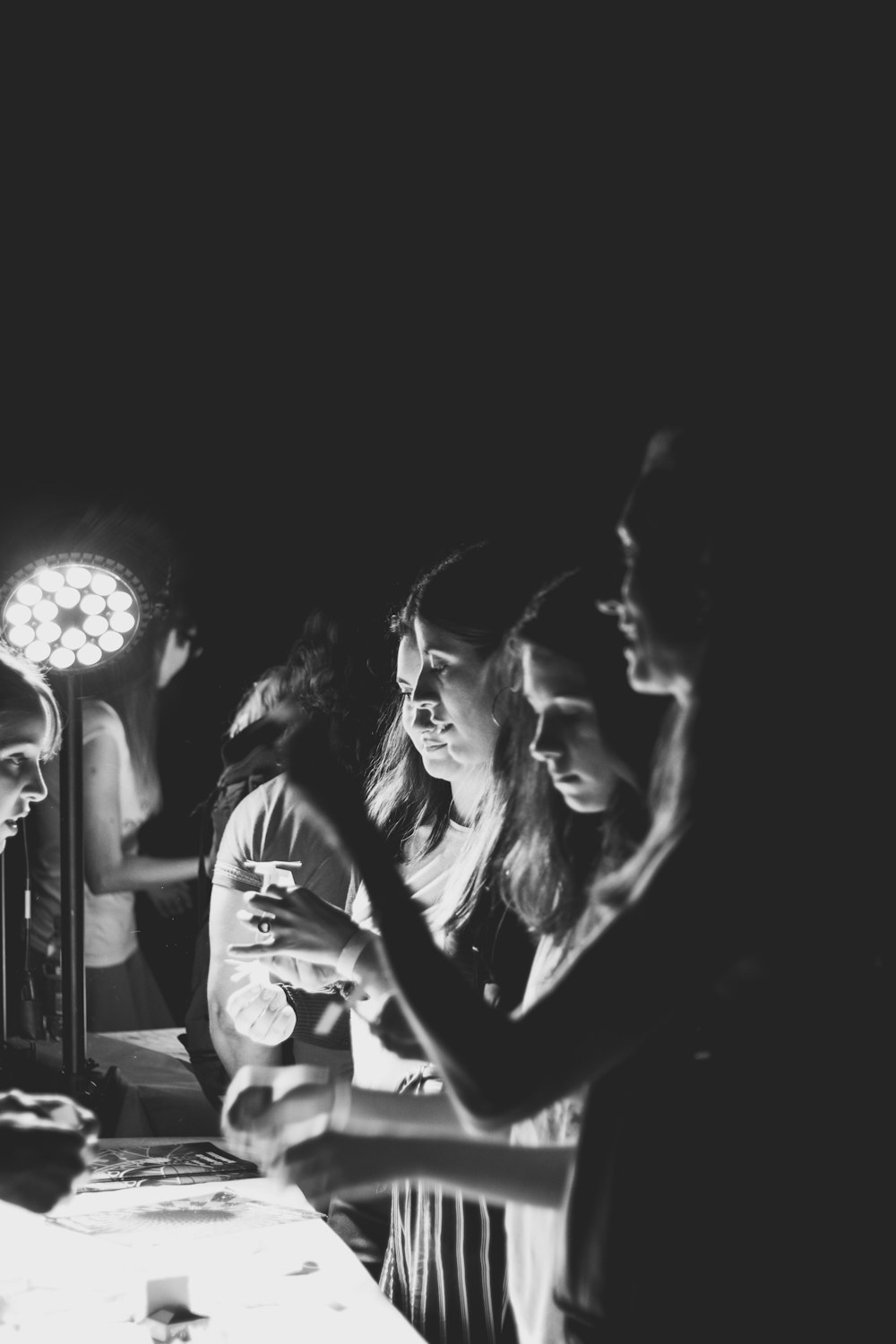 grayscale photography of women standing near table