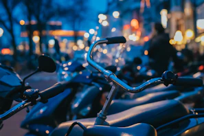 Artistic shot of Rizoma handlebars against a blurred urban nightscape, emphasizing style.