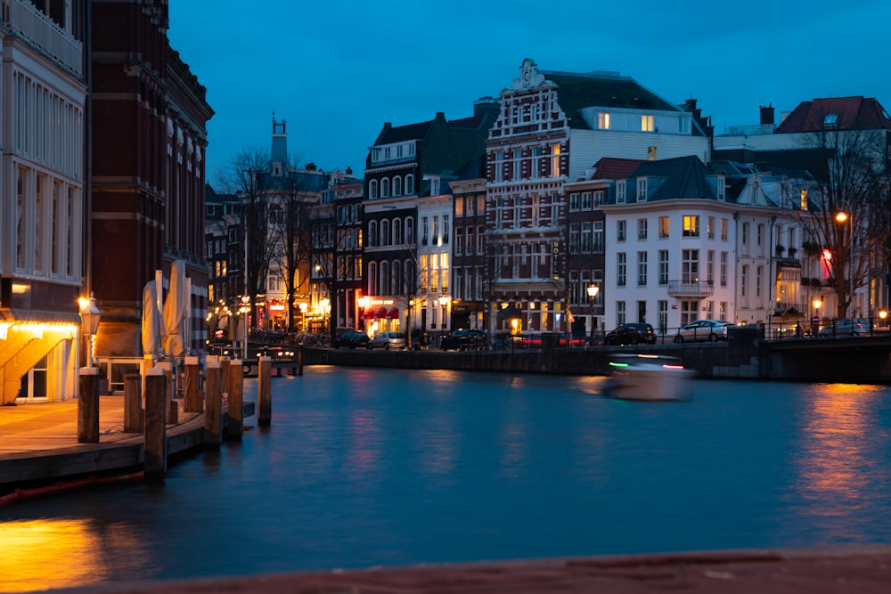 river near buildings at night-time