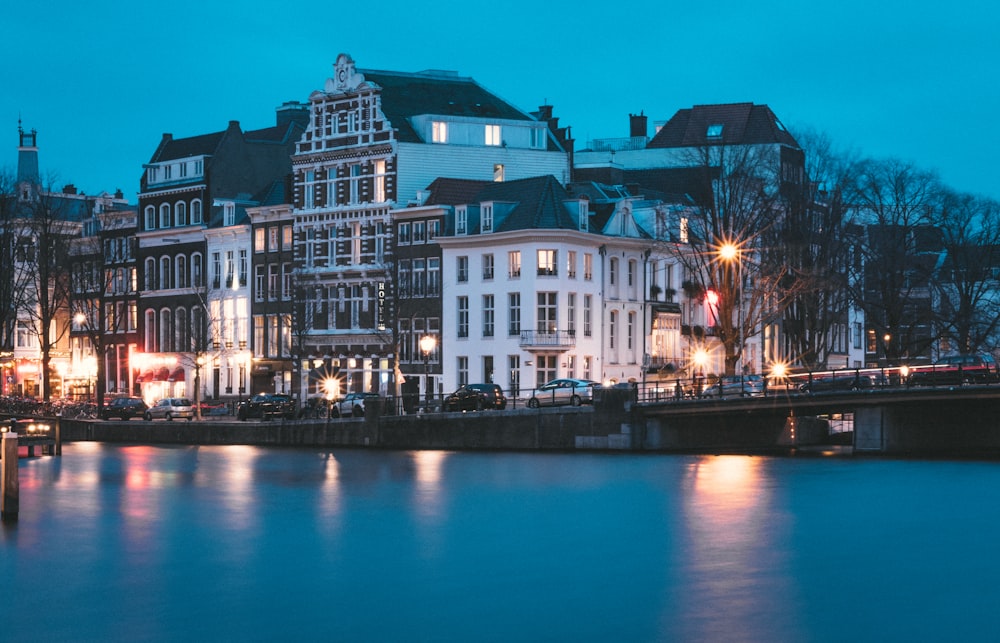 lighted lamp posts near white building beside body of water