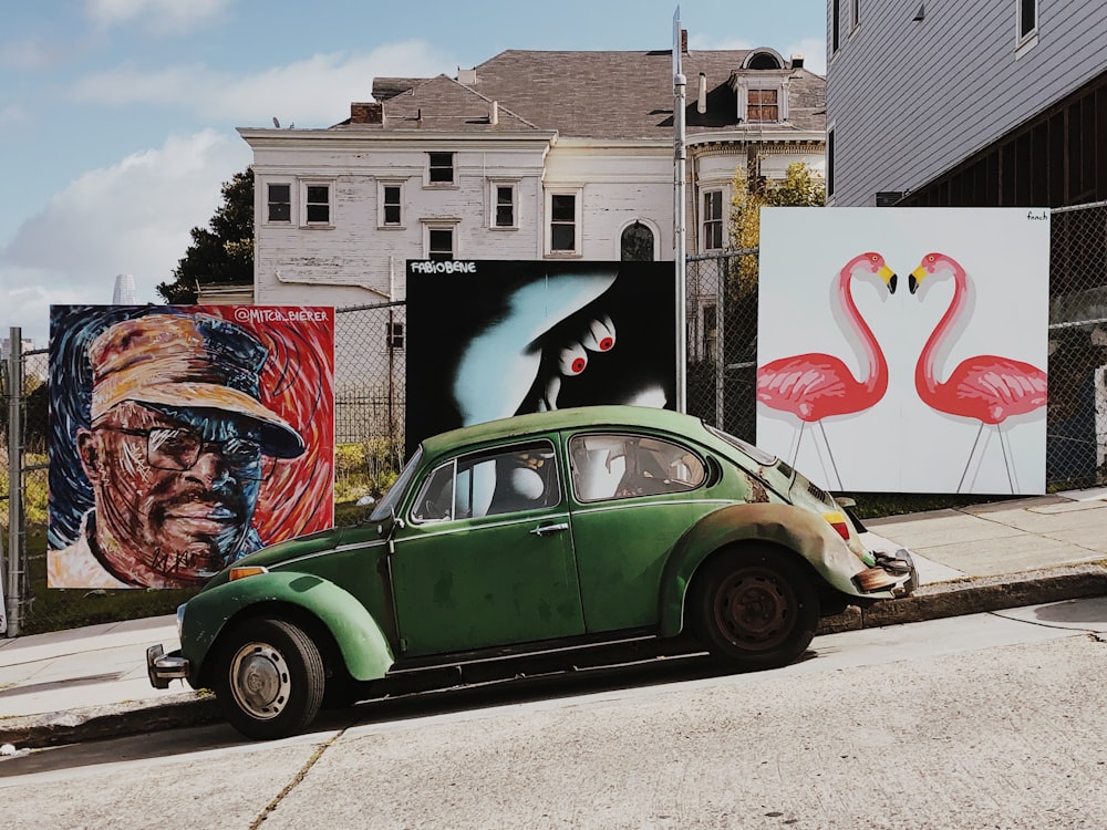 Volkswagen Beetle verde estacionado cerca de las artes de la pared