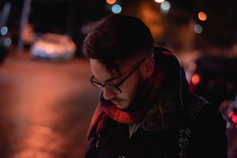 man wearing eyeglasses in selective focus photography