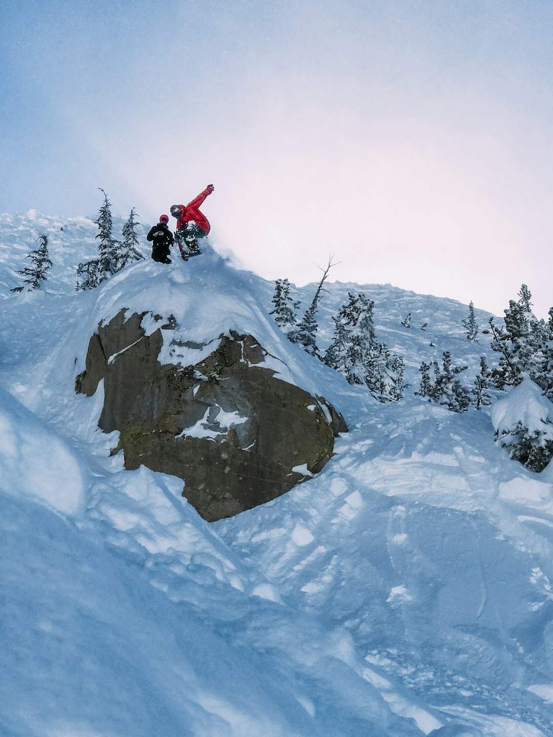 two person on cliff covered with snow