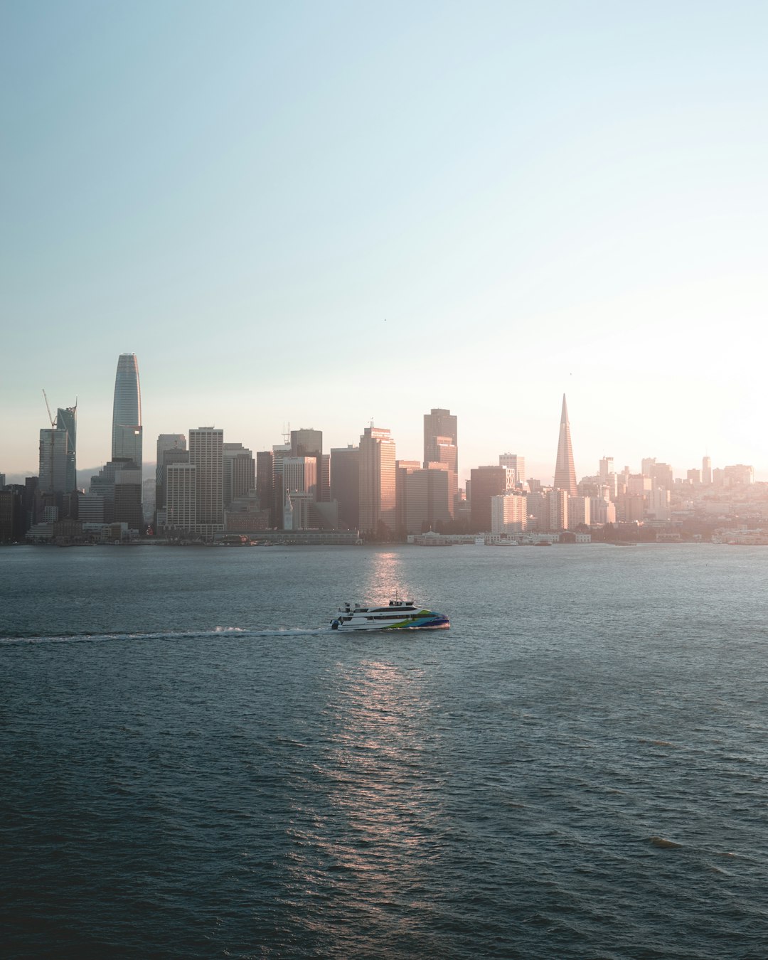 white boat on body of water with buildings ahead