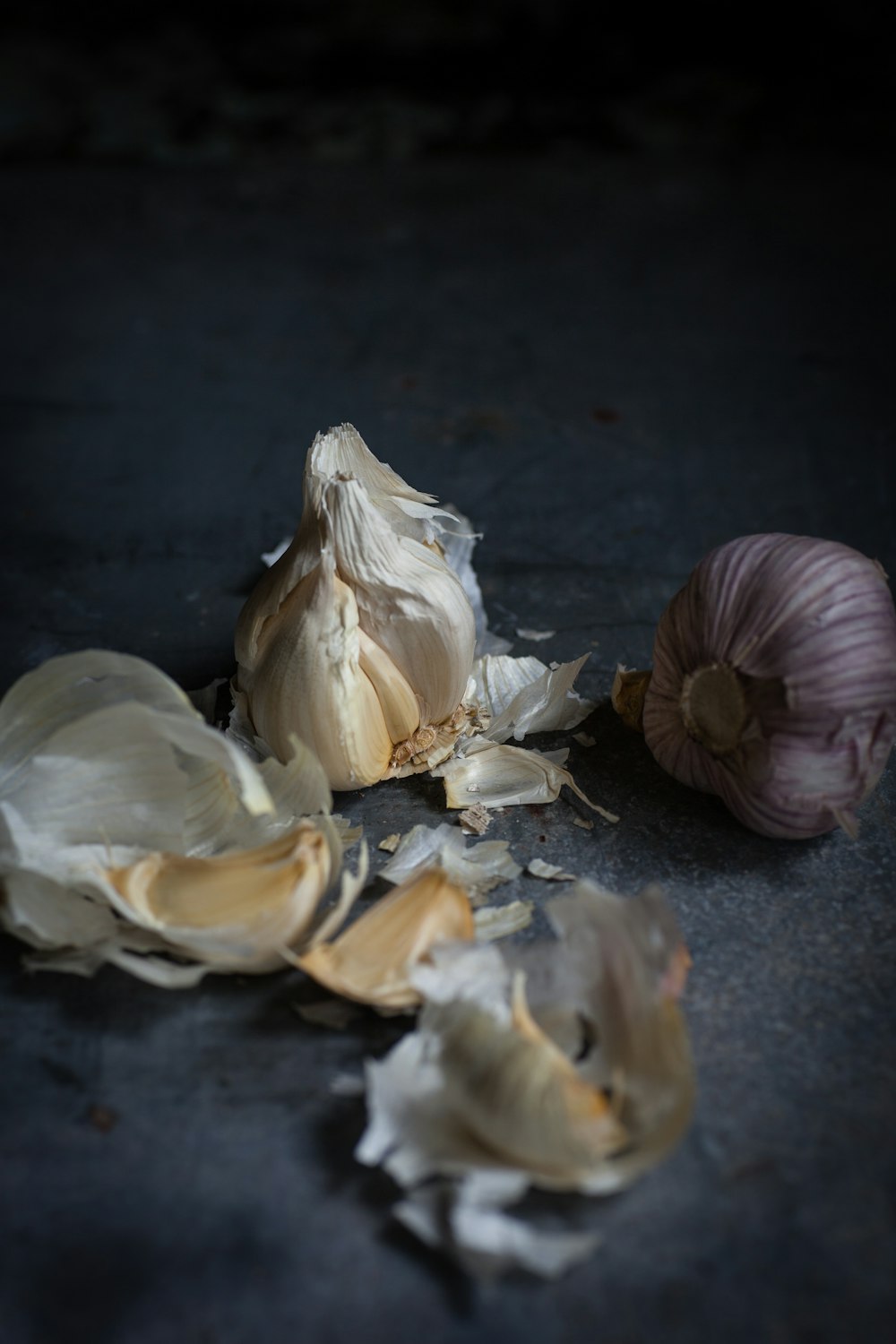 two close-up photography of garlic gloves on gray surface