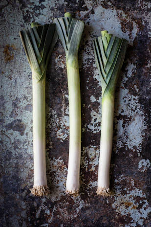 A rustic platter featuring leeks and other alliaceous vegetables ready to be served.