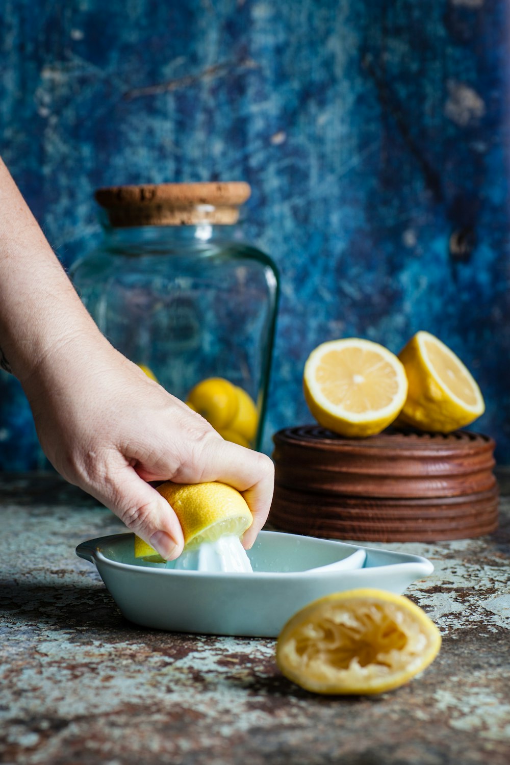 person squeezing lemon on citrus press on table