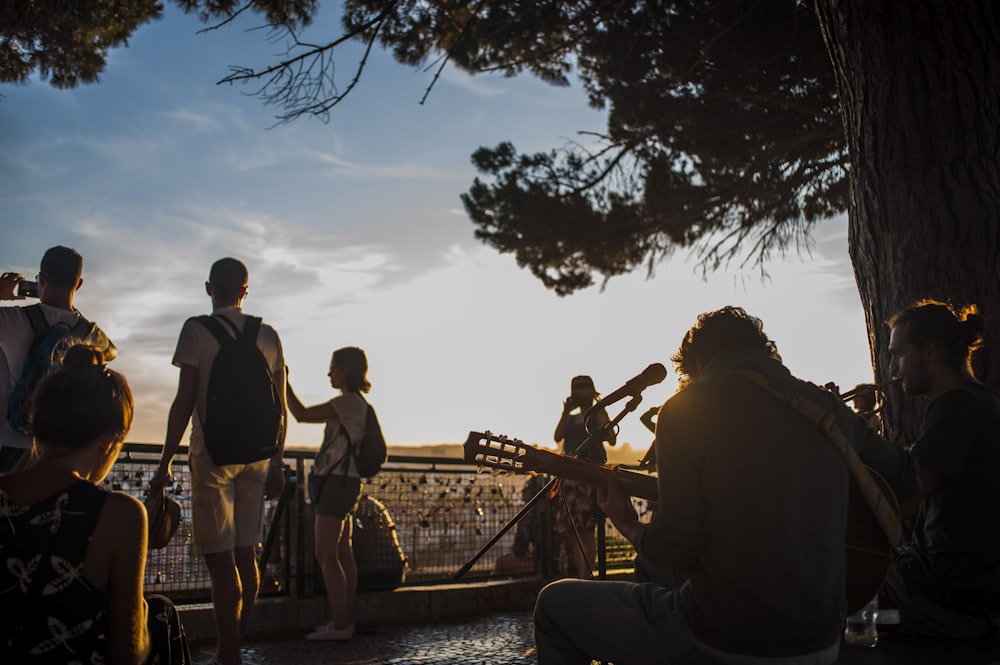 two men playing music in front of people during daytime