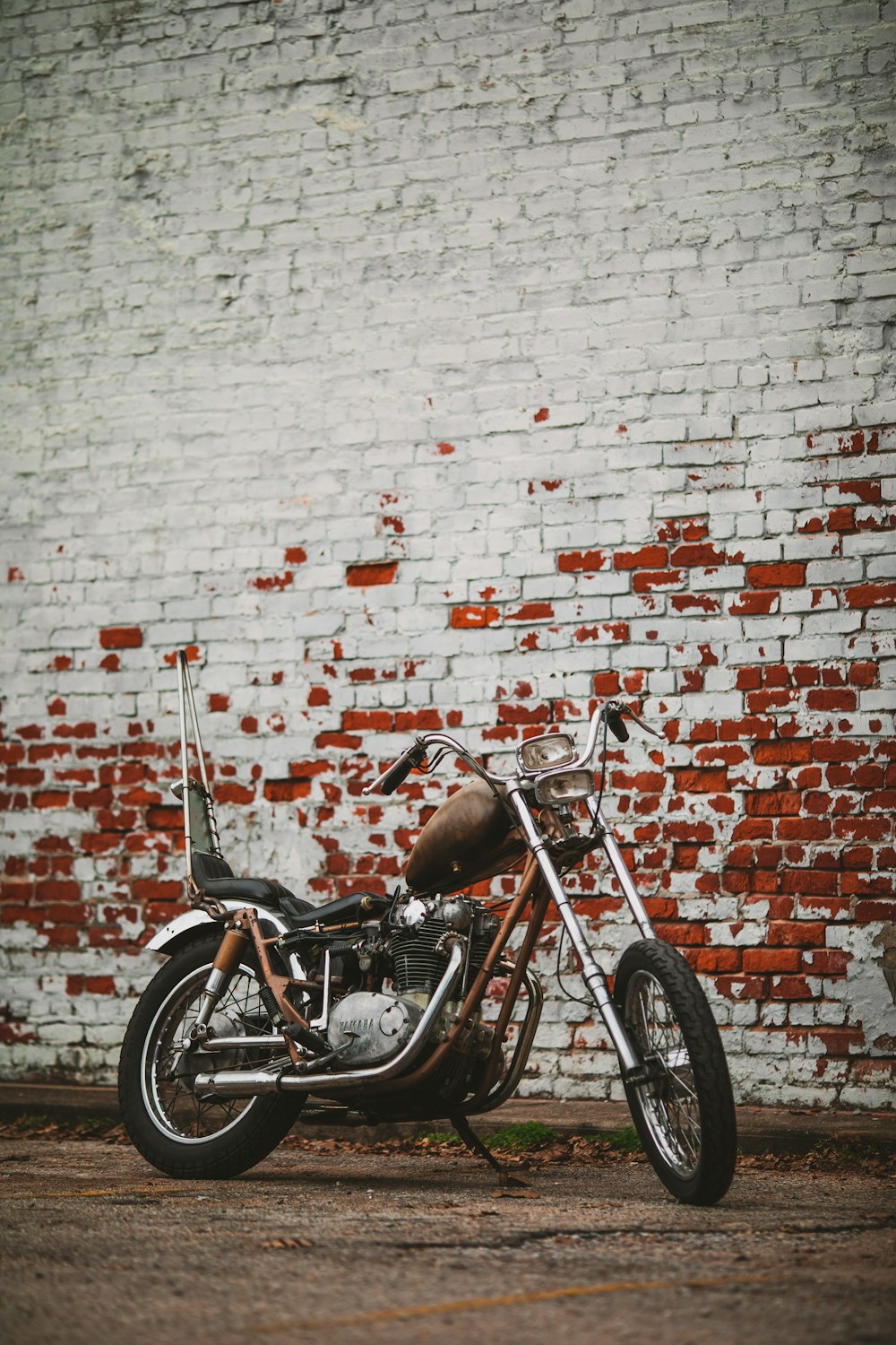brown and black motorcycle beside brown and red wall