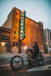 man riding on cruiser motorcycle near Alabama LED signage