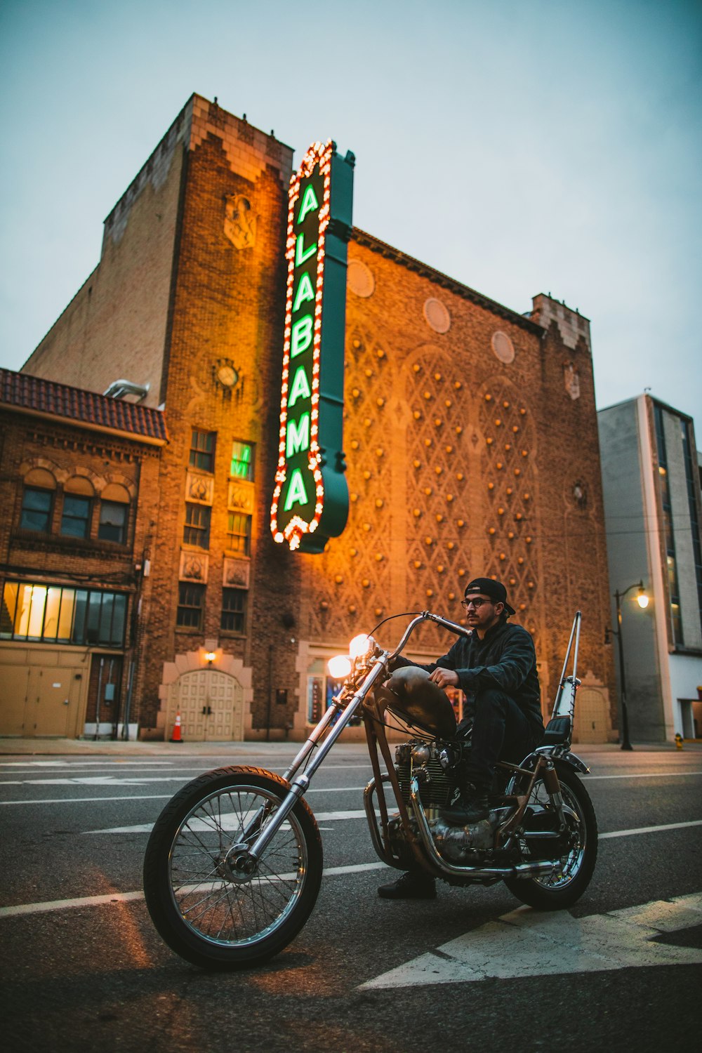man riding on cruiser motorcycle near Alabama LED signage