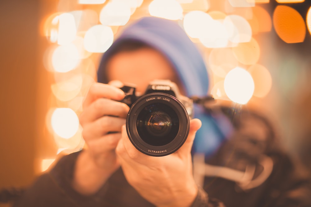 man holding Canon DSLR camera