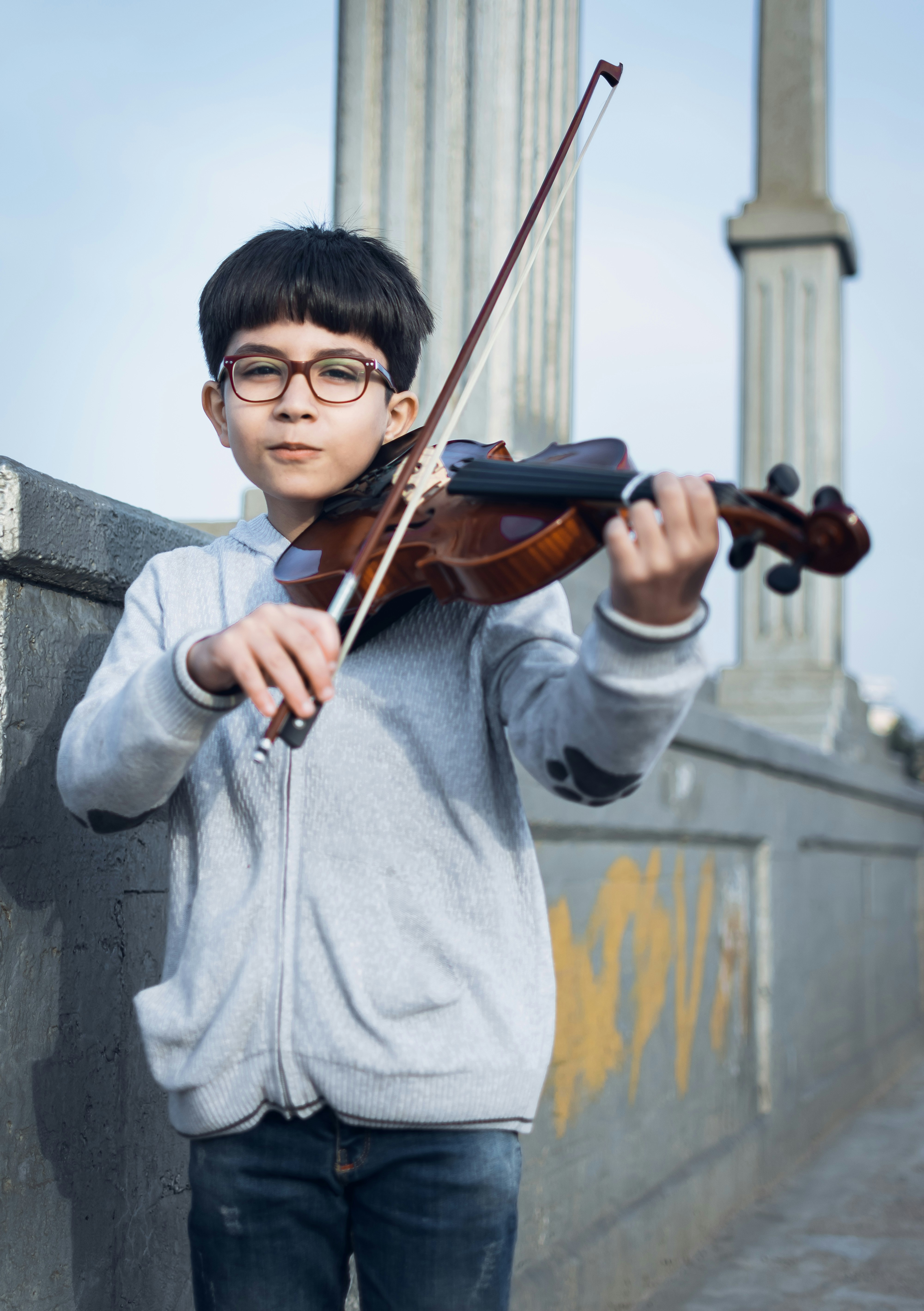 boy in gray zip-up jacket playing violin