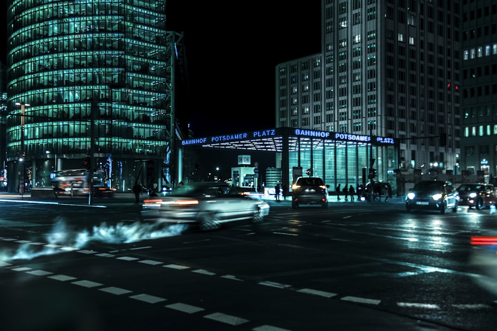 time-lapse photography of vehicles passing on curtain wall high-rise buildings during night