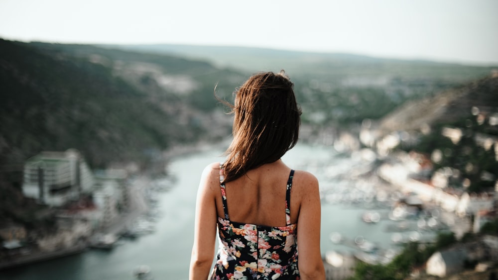 woman facing villages near river