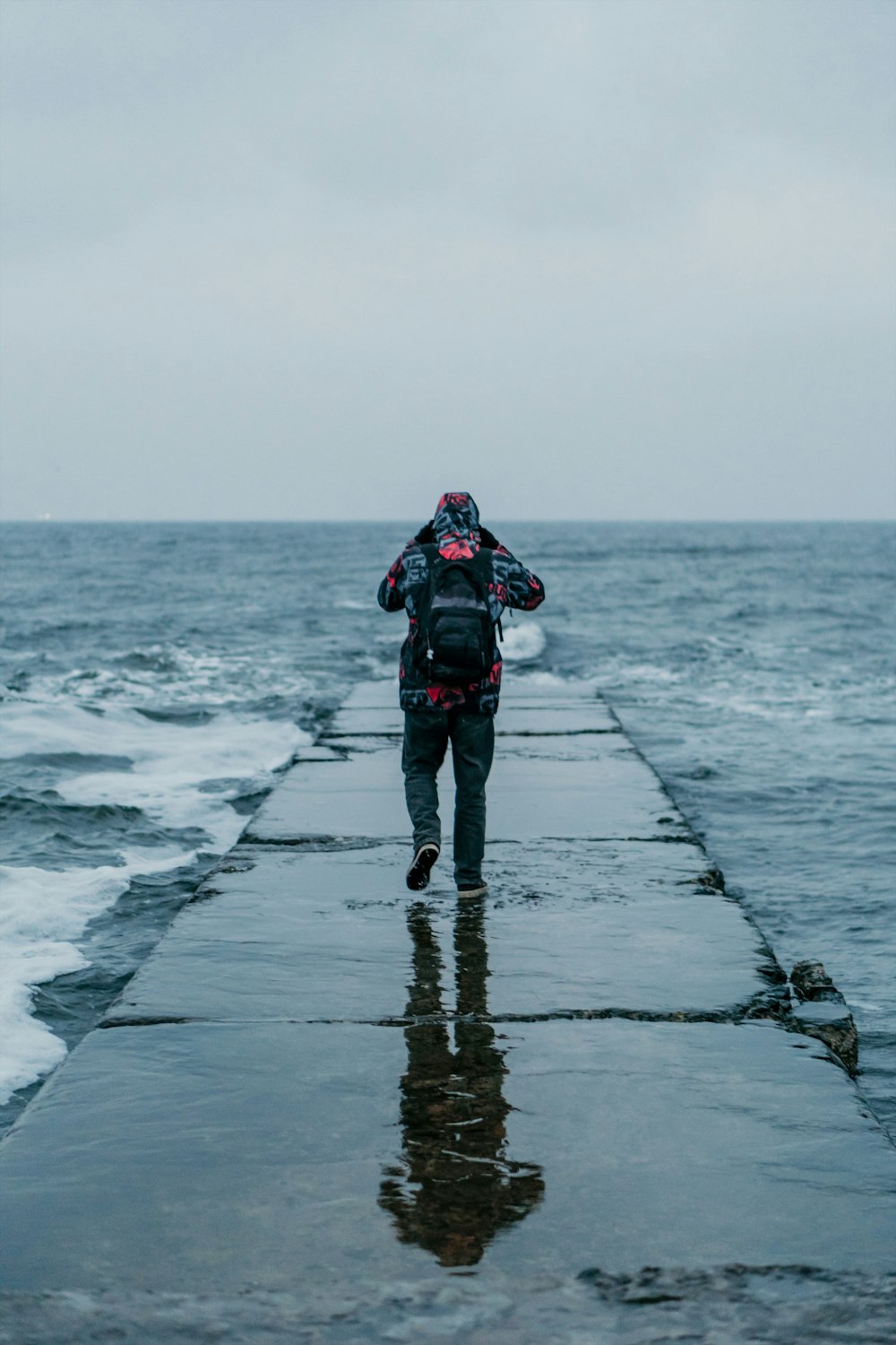 person standing on concrete baywalk