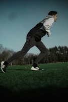 A runner in motion wearing breathable luxury activewear, captured mid-stride in a park.