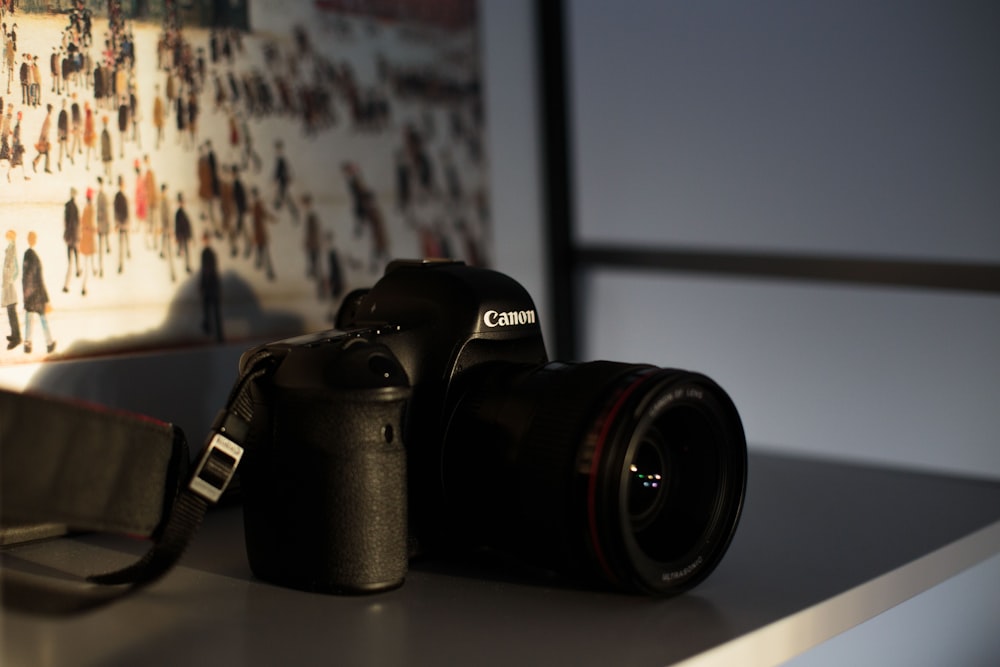 black Canon DSLR camera on table