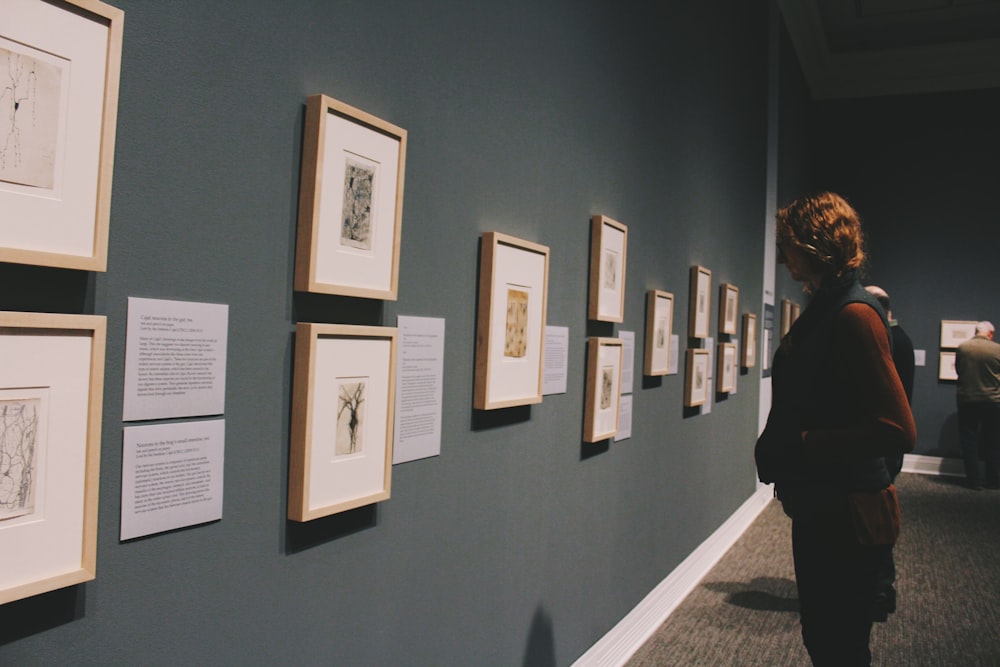 woman looking at wall frames