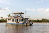 The deck of a budget-friendly houseboat featuring comfortable chairs and scenic river views.