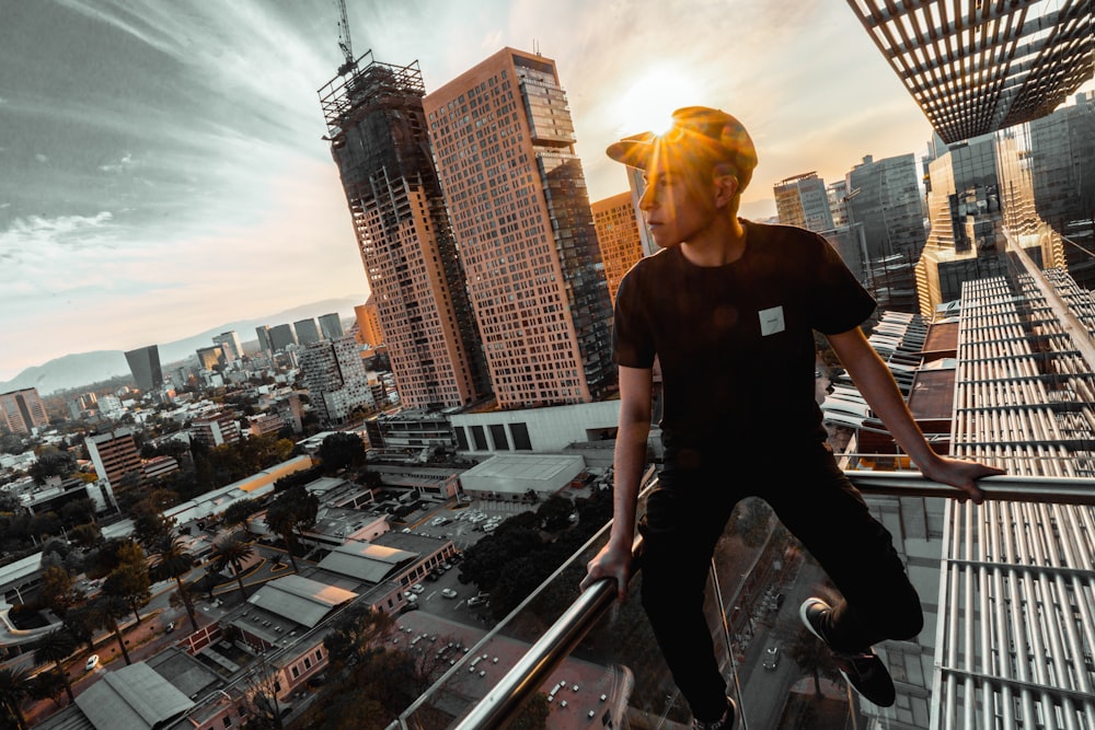 man sitting on rail of building