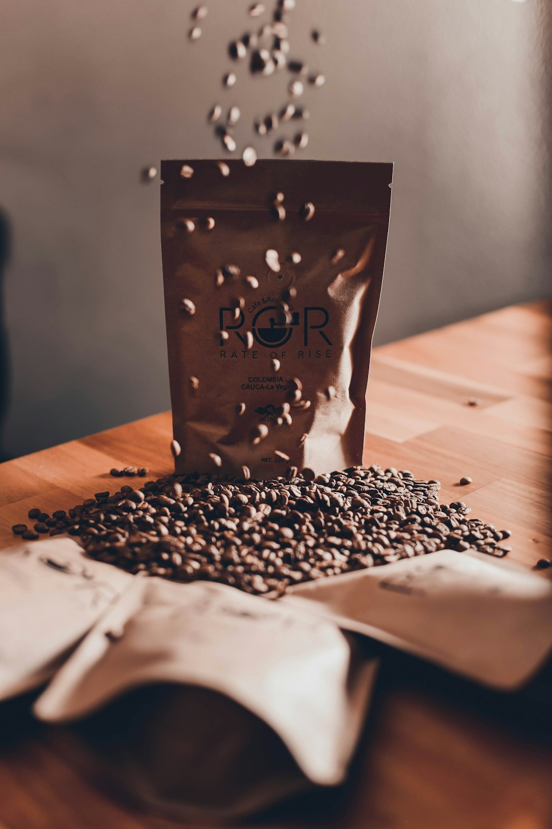 person pouring beans on brown wooden table