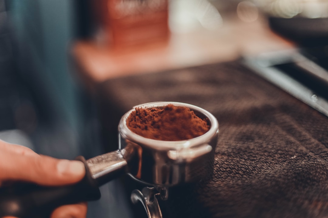 person holding cup with coffee powder