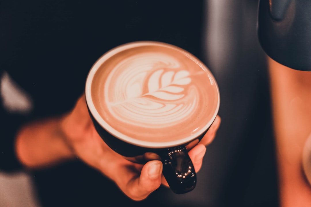 person holding cup of coffee latte