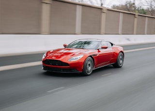 red coupe passing on road