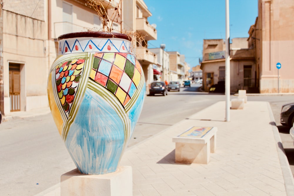 blue and multicolored decorative vase near street during daytime