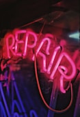 red and blue repair neon light signage close-up photo