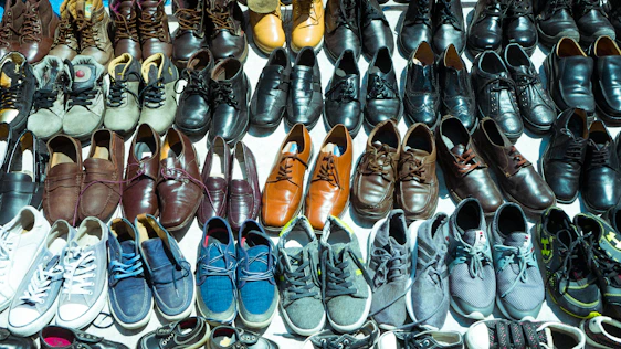 A cozy entryway featuring neatly arranged wooden and plastic shoe racks filled with various shoes.
