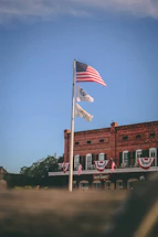 A warm photo of the VFW Bryan Tutten Memorial Post 2391 building with an American flag waving gently in front.