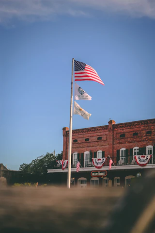 A scenic view of Horseshoe Bend city hall with flags waving under a clear sky.