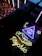 A neon sign with a glowing eye inside a triangle, accompanied by a star and crescent moon motif. Below, the word 'psychic' is illuminated in bright yellow neon. The scene is set against a backdrop of reflective and textured surfaces.