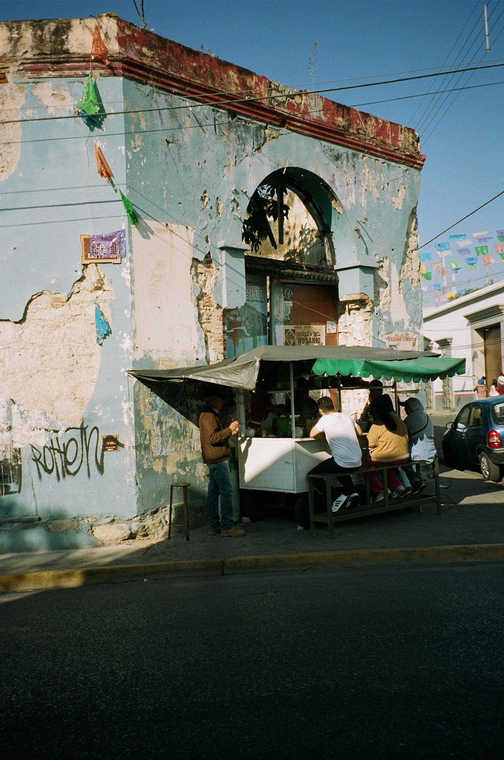 three people sitting on food stall