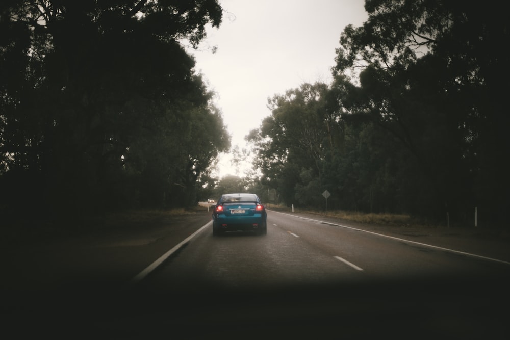 blue car traveling on road