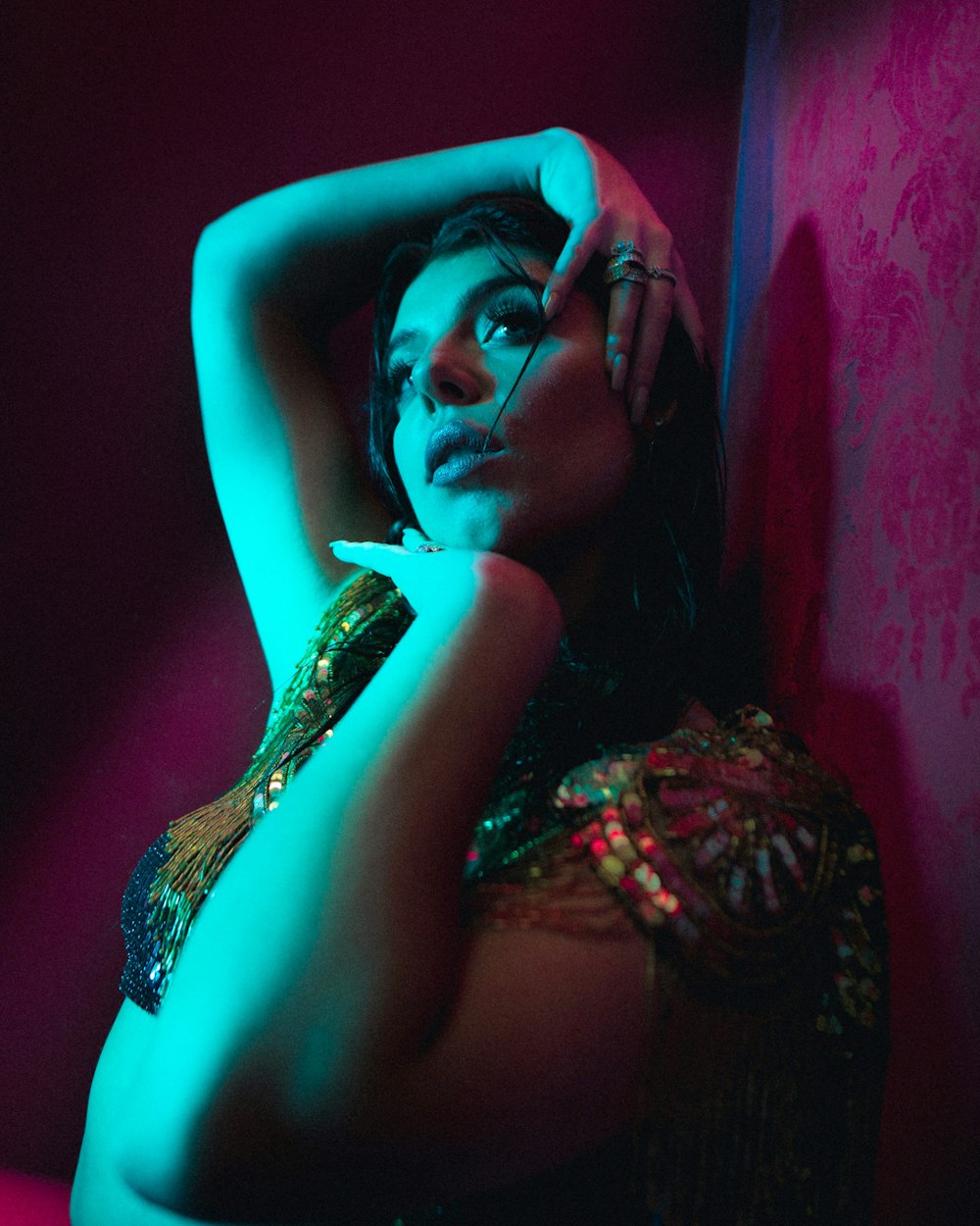 woman leaning on wall inside dim-lit room