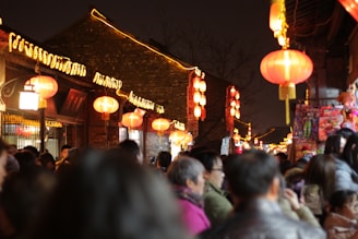 A vibrant street scene in Guangzhou at dusk, with glowing red lanterns and bustling night markets.