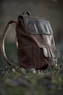 brown and black leather backpack on ground