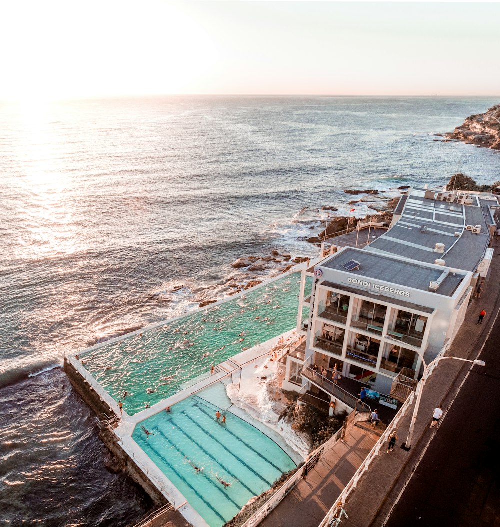 house with swimming pool beside sea during daytime